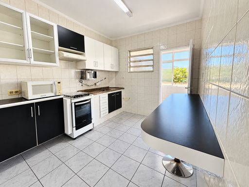 Cozinha com geladeira, fogão e coifa