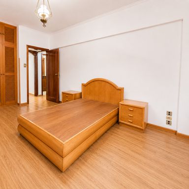 Dormitório com cama e mesas de cabeceira