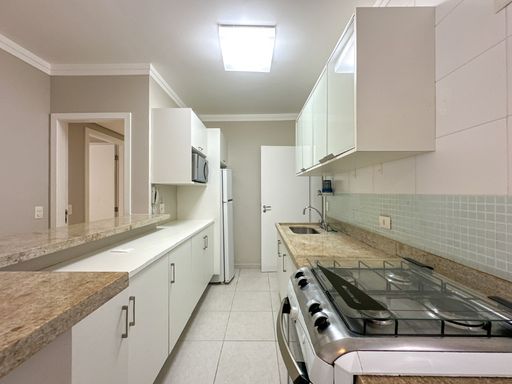 A cozinha americana, com armários embutidos que otimizam o espaço.