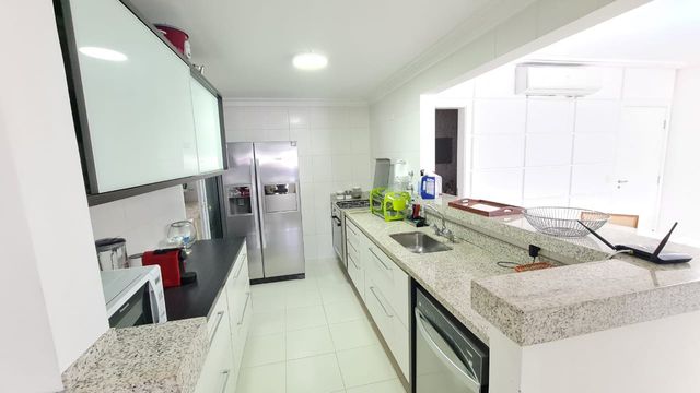 A cozinha completa, com bancadas amplas e equipamentos modernos.