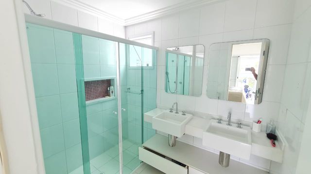 A funcionalidade de um dos banheiros com duas pias, trazendo praticidade e elegância.