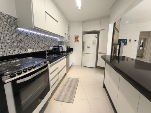 A cozinha no estilo americana, com bancada e totalmente equipada.