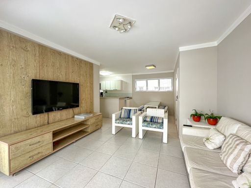 A sala de estar, com seu design moderno e a iluminação natural do sol da manhã, cria um ambiente aconchegante e perfeito para o convívio.