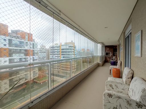 A sacada do apartamento com vista para a área de lazer.