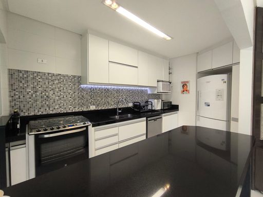 Detalhe da cozinha equipada, mostrando os eletrodomésticos modernos.