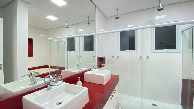 A funcionalidade de um dos banheiros com duas pias, ideal para a rotina de um casal ou para a comodidade dos hóspedes.