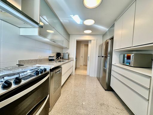 A cozinha completa, com armários planejados e eletrodomésticos de última geração.