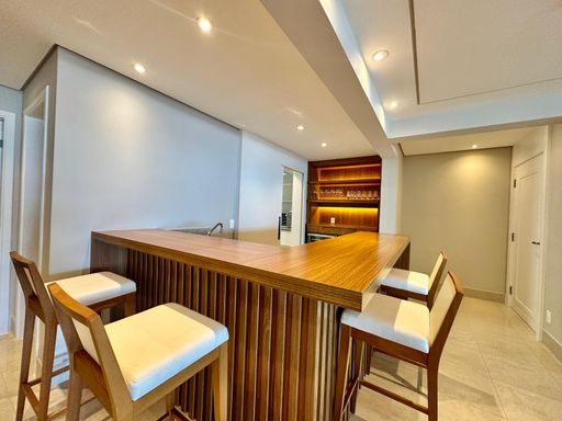 A cozinha aberta para a sala, garantindo interação com os convidados enquanto prepara as refeições.