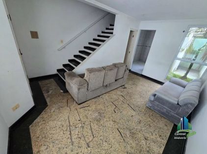 Hall de entrada com paredes brancas e escada com piso de madeira