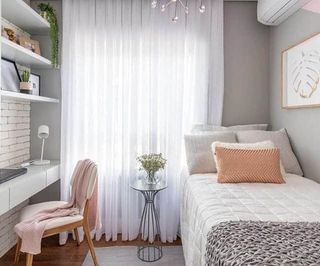 quarto com paredes cinza com cama de solteiro e escravaninha branca