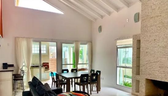 Sala da jnata com pé direto alto  uma mesa de jantar para 8 pessoas