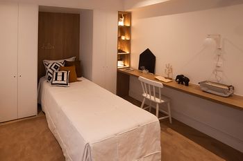 Quarto solteiro com ambiente para estudo.