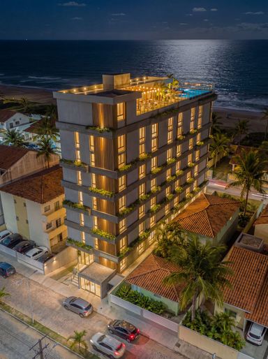 Fachada noturna com iluminação sofisticada reforçando o pardo do empreendimento.