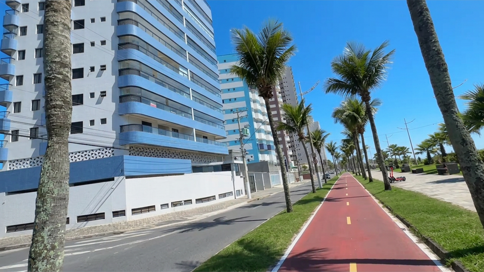 Vista da orla da Vila Caiçara em Praia Grande SP com ciclovia palmeiras e edifícios residenciais
