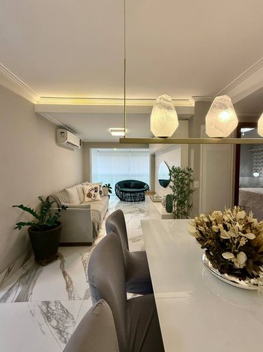 Sala com varanda integrada, marcenaria e iluminação diferenciada