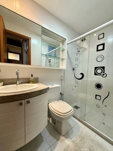 Suíte com armários embutidos e banheiro com ventilação natural