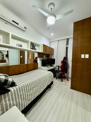 Suíte com armários embutidos e banheiro com ventilação natural