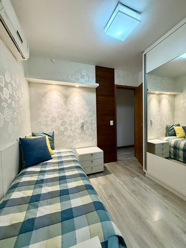 Suíte com armários embutidos e banheiro com ventilação natural