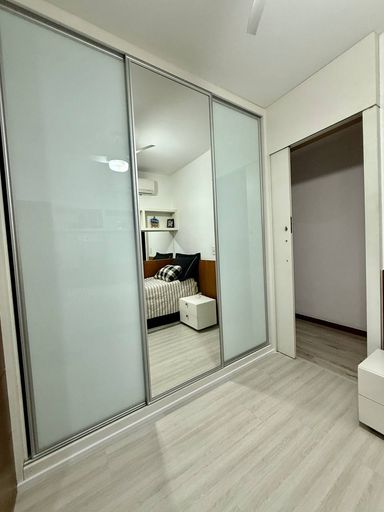 Suíte com armários embutidos e banheiro com ventilação natural