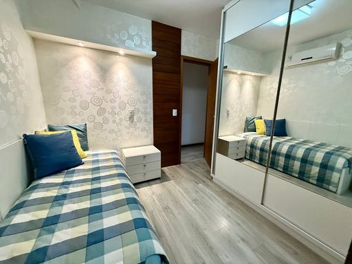 Suíte com armários embutidos e banheiro com ventilação natural
