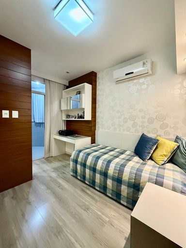 Suíte com armários embutidos e banheiro com ventilação natural