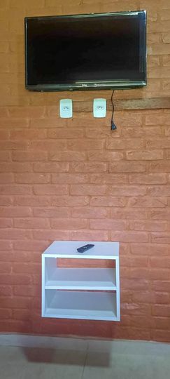 area comum que une sala de estar e jantar com Tv na parede