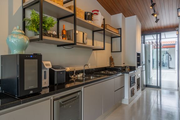 Varanda gourmet com ilha, planejados, churrasqueiras elétrica e a carvão, fogão e forno elétricos, fogão à lenha, forno à lenha, espaço para cooler, para adega e lavalouças.