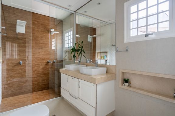 Suite juvenil: banheiro com bancada com 2 cubas, gabiente, 2 chuveiros.