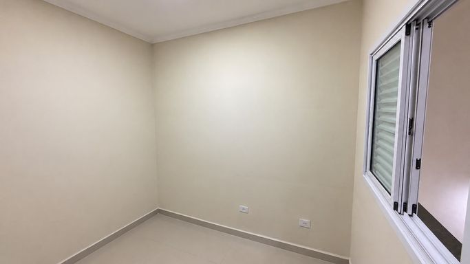 Dormitório versátil, ideal também para escritório ou home office, com porcelanato, janela em alumínio e iluminação em LED.