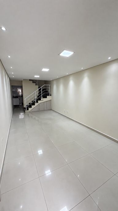 Vista interna da sala, mostrando o acesso à cozinha, à escada em granito e o aproveitamento do espaço sob os degraus.