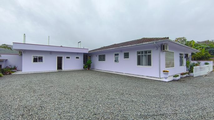 Lateral da casa e pátio com brita - casa à venda em Águas Mornas/SC