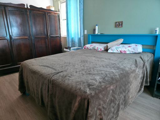 Dormitório casal com cama e guarda roupas