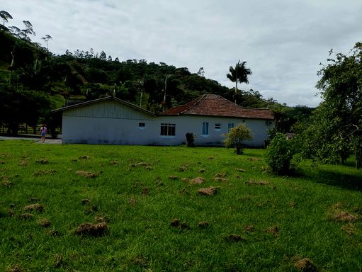 Pastagem e casa ao fundo