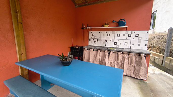 Cozinha com parede laranja e mesa azul