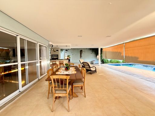 Amplo espaço para mesa que atende a área da churrasqueira com vista para a piscina
