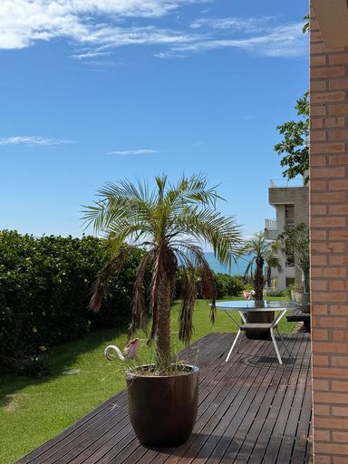 Varanda com vista para o mar e jardim