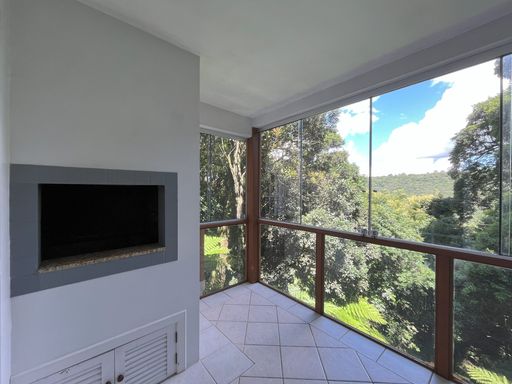 Área gourmet com churrasqueira, ambiente fechado com vidro.