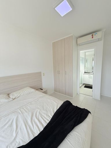 Suíte com cama de casal, armários planejados e ar condicionado.