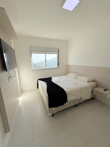 Suíte com cama de casal, armários planejados e ar condicionado.