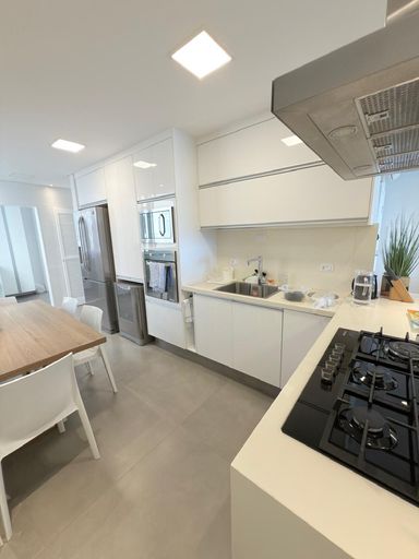 Cozinha integrada a sala de janatar com copa, repleto de armários e mesa com 4 cadeiras