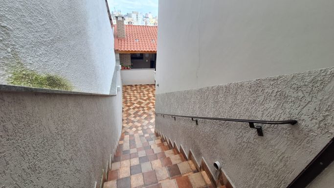 escadas acesso área gourmet com churrasqueira , quinta, lavanderia, deposito e salão de festas.