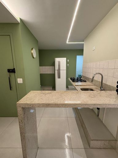 Sala e cozinha em conceito aberto com bancada cascata (de granito)