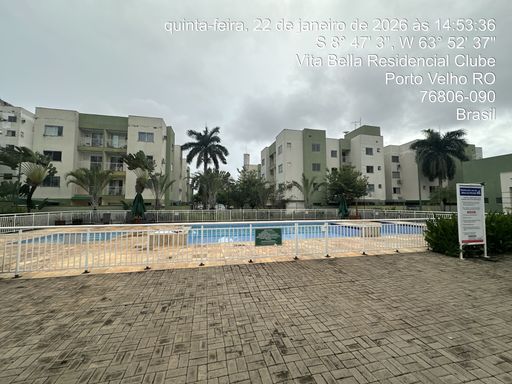 Área de lazer do Condomínio Vita Bella Porto Velho RO, com piscina ampla, espaço aberto e prédios residenciais ao fundo.