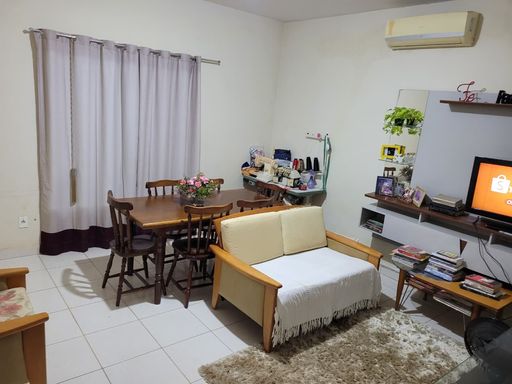 Vista complementar do living integrado evidenciando o sistema de climatização tipo split instalado e ampla janela protegida por cortina de tecido no Bairro Aeroclube, em Porto Velho-RO.