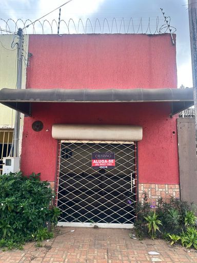 Fachada de sala comercial disponível para locação no Bairro Caladinho, em Porto Velho/RO. O imóvel possui porta de enrolar metálica e toldo de proteção, sendo uma excelente opção para pequenos comércios ou escritórios de serviços com visibilidade local.