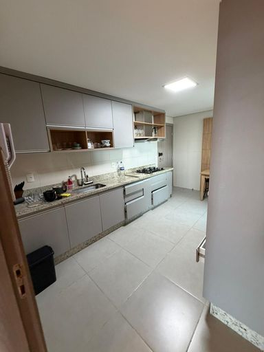 Cozinha espaçosa com móveis planejados e totalmente equipada, acabamento moderno em apartamento de luxo em Porto Velho.