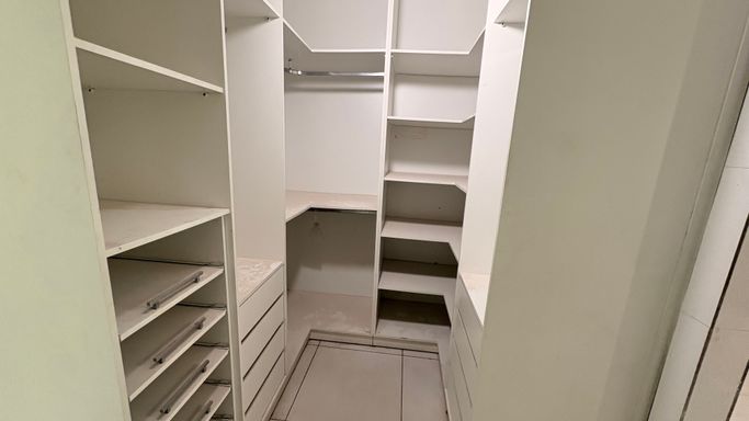 Detalhe da marcenaria do closet moderno com amplo espaço de arrumação nesta casa na zona sul de Porto Velho, ofertada por imobiliária em Porto Velho