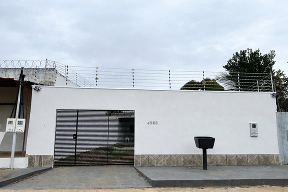 Detalhe do fechamento frontal com muro alto, portão metálico de correr e sistema de segurança robusto com cerca elétrica e concertina no Bairro Nova Esperança, em Porto Velho-RO.