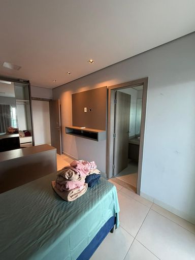 Suíte espaçosa com móveis planejados e acesso direto à sacada, proporcionando conforto e iluminação natural.