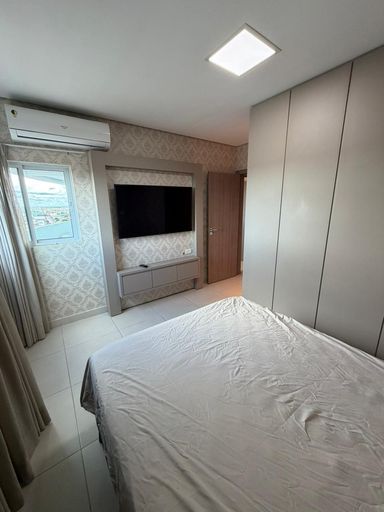 Suíte mobiliada com armários planejados e painel para TV, ambiente aconchegante em apartamento de luxo no centro de Porto Velho.